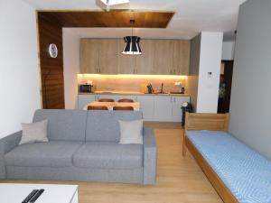 a living room with a couch and a kitchen at Wellness Rezort Tatranská Štrba in Štrbské Pleso +31 photos