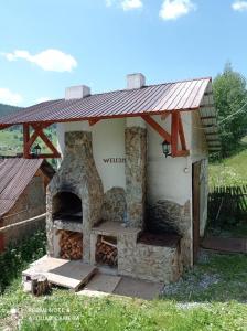 a stone oven with a roof on top of it at Vila Bucovina in Ciocăneşti