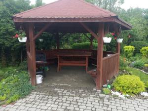 a wooden gazebo with a picnic table in a garden at Domek u Doroty Orelec k Soliny in Orelec