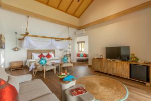 a living room with a couch and a television at Pax Ana Doc Let Resort & Spa in Ninh Hòa