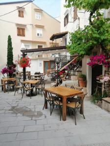 eine Außenterrasse mit Holztischen und -stühlen in der Unterkunft ANCHOR BAŠKA in Baška