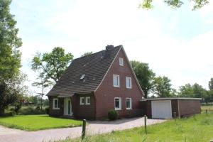 a house with a gambrel roof and a garage at Ferienhuus 35 in Leer