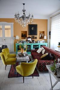 a living room with a couch and yellow chairs at Vintage Luxurious house in Sombor