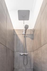 La salle de bains est pourvue d'une douche avec un pommeau de douche. dans l'établissement Bett im Bahnhof Güterschuppen, à Bad Harzburg