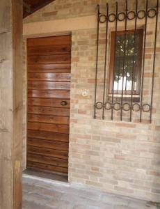 eine Holztür an einer Ziegelwand mit einem Fenster in der Unterkunft Casa Sabbatini in SantʼElpidio a Mare