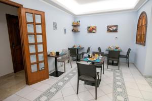 Un comedor con mesas y sillas y una puerta. en B&B Azul, en Palermo