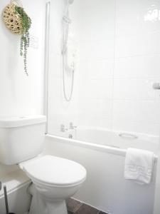 Un baño blanco con inodoro y bañera. en Nordic Suites Apartments, Ulverston, en Ulverston 50 fotos más