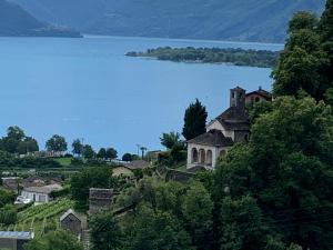 a house on a hill next to a body of water at Appartamento ai Ronchi in Gordola