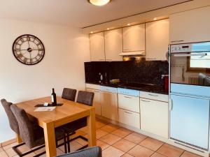 a kitchen with a table and a clock on the wall at Appartamento ai Ronchi in Gordola