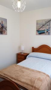 1 dormitorio con 1 cama y 2 cuadros en la pared en Apartamento Julieta, en San Vicente de la Barquera