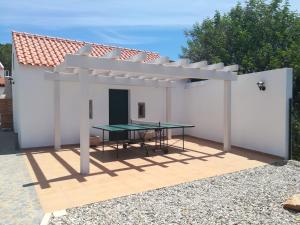 a white pergola with a table and a table top at Villa Rominha Alvaiázere - Casa do Canteiro in Alvaiázere