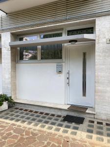 białe drzwi wejściowe domu z oknem w obiekcie Manuel's Home 1 FREE parking Wi-Fi AC w mieście Bolzano