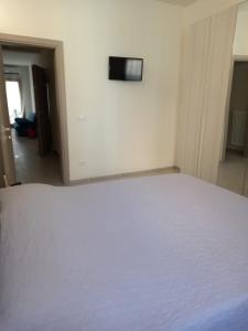 a white bed in a room with a television on the wall at Casa Alice in Chioggia +3 photos