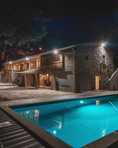 a house with a swimming pool at night at Quinta de Requeixo in Guimarães