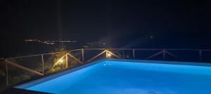 a night view of a swimming pool on a balcony at Azienda Agrituristica La Janna di la Faj in Budoni