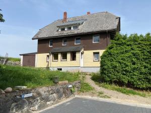 a large house with a stone wall in front of it at Ferienhaus Frei 3 Budget in Titisee-Neustadt