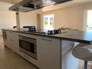 a kitchen with a stove and a counter top at Maison vue mer Propriano Viggianello in Viggianello +11 photos