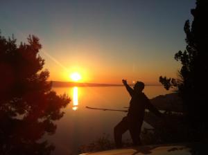 a man standing on the edge of a lake at sunset at Villa Panorama in Omiš