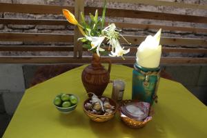 a green table with a vase with flowers and baskets of fruit at Guest house and Cuisine by Meri Poppins in Dedoplis Tskaro