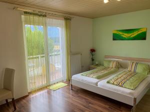 um quarto com uma cama e uma grande janela em Privatzimmer Haus Waltraud am Turnersee em Obersammelsdorf