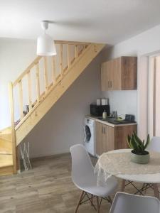 a living room with a table and a staircase at Apartament Pod Wiśnią in Supraśl