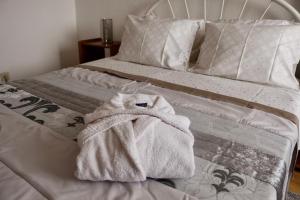 a white bed with a towel on top of it at Casa Teresinha in Sesimbra