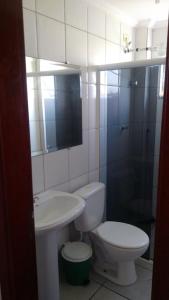 y baño con aseo, lavabo y ducha. en Edifício Santorini en Mongaguá