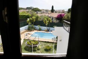 a view of a swimming pool from a window at Casa Teresinha in Sesimbra