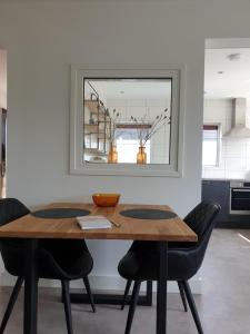 a dining room table with black chairs and a mirror at Vakantiewoning "In Between" in Oostkapelle +20 photos