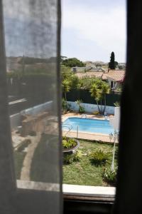 a view of a swimming pool from a window at Casa Teresinha in Sesimbra