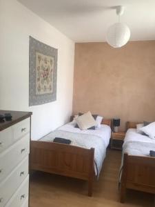 a bedroom with two beds and a dresser at Apartament Pod Wiśnią in Supraśl