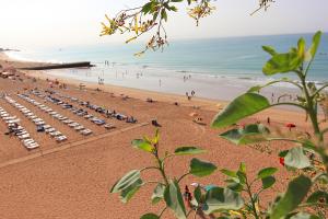 a beach with a bunch of chairs and the ocean at Natural Grey Albufeira in Albufeira
