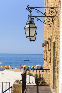 a street light on the side of a building next to the beach at Natural Grey Albufeira in Albufeira