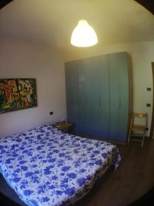 1 dormitorio con 1 cama azul y armario en Il Casale del Vento, en Campodonico