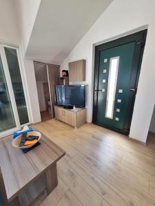un soggiorno con una grande porta verde e una TV di Apartmani Latin Jezera a Jezera