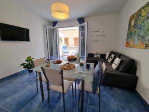 a living room with a table and a couch at Le petite Maison in San Vito lo Capo
