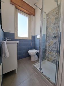 a bathroom with a toilet and a glass shower at Le petite Maison in San Vito lo Capo +30 photos