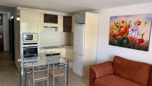 a kitchen with a couch and a painting on the wall at Apartment Parque Royale 1 in Adeje