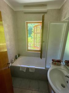 a bathroom with a tub and a sink and a window at Apartment Olive Grove in Izola