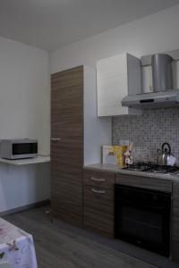 a kitchen with white cabinets and a stove top oven at La tana dello zio Gio in Endine Gaiano