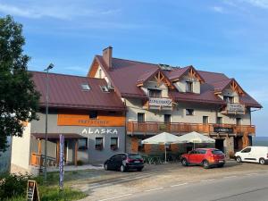 a large building with cars parked in a parking lot at Przystanek Alaska in Zieleniec