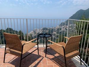 two chairs and a table on a balcony with a view at Casa Ministro in Positano