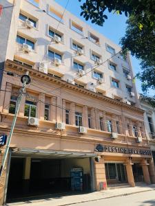 a large white building on the corner of a street at Destino Real Hotel in Buenos Aires