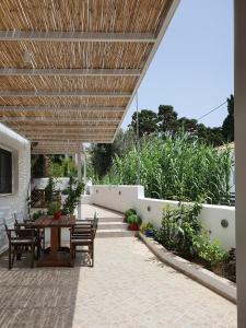 un patio con mesa y sillas bajo una sombrilla de madera en Moscha Studios, en Batsi