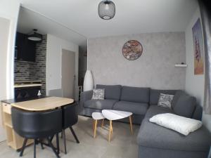 sala de estar con sofá y mesa en Le COCON CABOURGEAIS en Cabourg