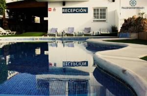 una piscina con sillas y un hotel en HOTEL Palomares Beach, en Palomares