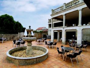 a fountain in the middle of a patio with tables and chairs at Albergue Villa San Clemente in Tui