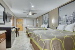 a hotel room with four beds and a chalkboard at Texas Inn Donna in Donna +26 photos