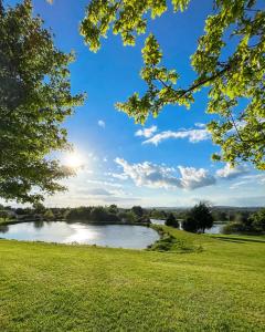 a view of a river from a field with trees at Southern County Resort in Sheean