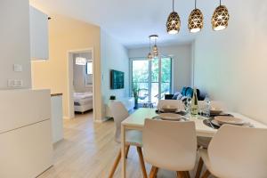 a kitchen and dining room with a table and chairs at M&K Apartament Nadmorski Zagajnik - Sobieszewo, Wyspa Sobieszewska in Gdańsk